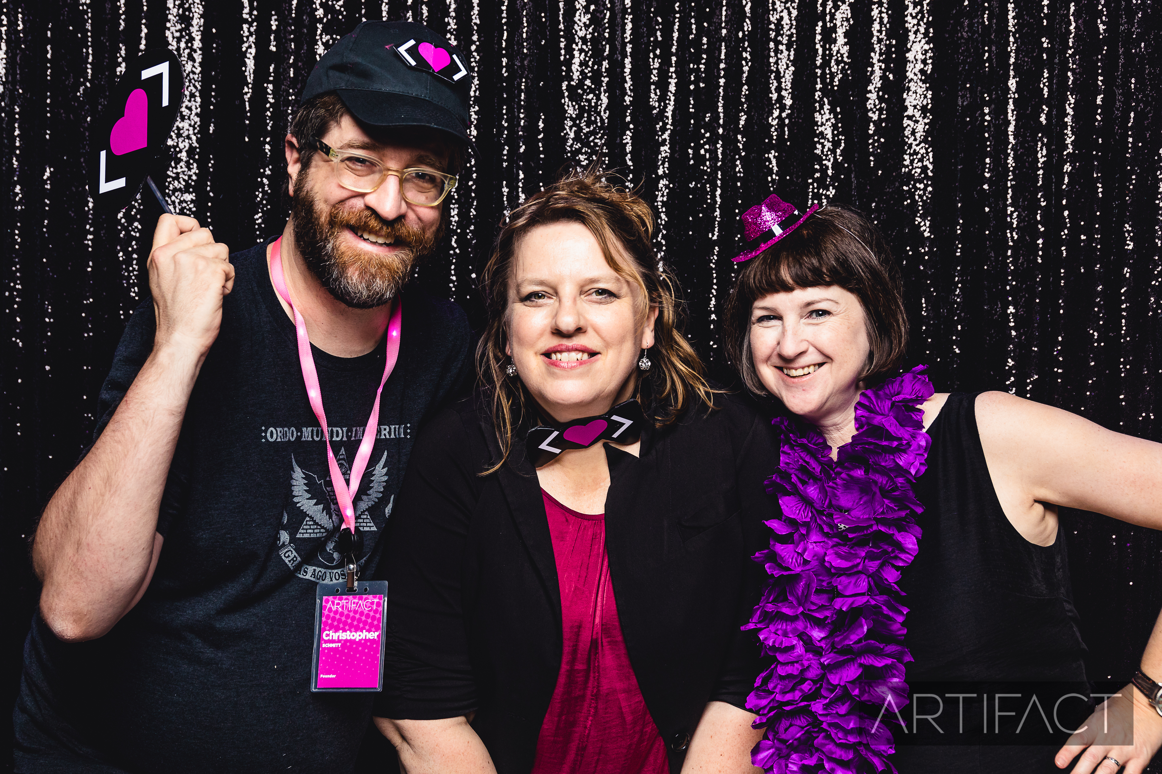 Christopher, Ari, and Jennifer in the photo booth smiling at Artifact Conf